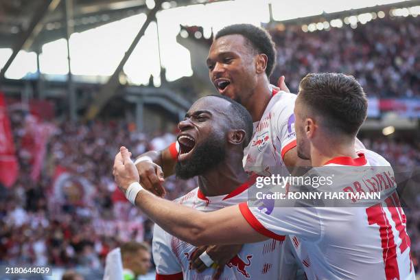 Leipzig's Dutch defender Lutsharel Geertruida celebrates with his team mates Belgian forward Lois Openda and Austrian midfielder Christoph...
