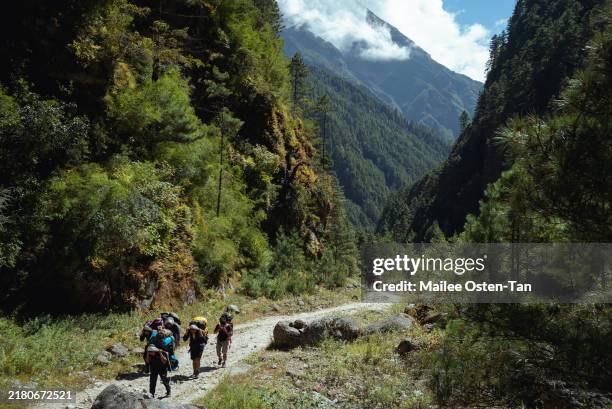 Trekkers and porters make their way through the mountains, heading towards to Tenzing-Hillary bridge on October 07, 2024 in Namche Bazaar, Nepal....