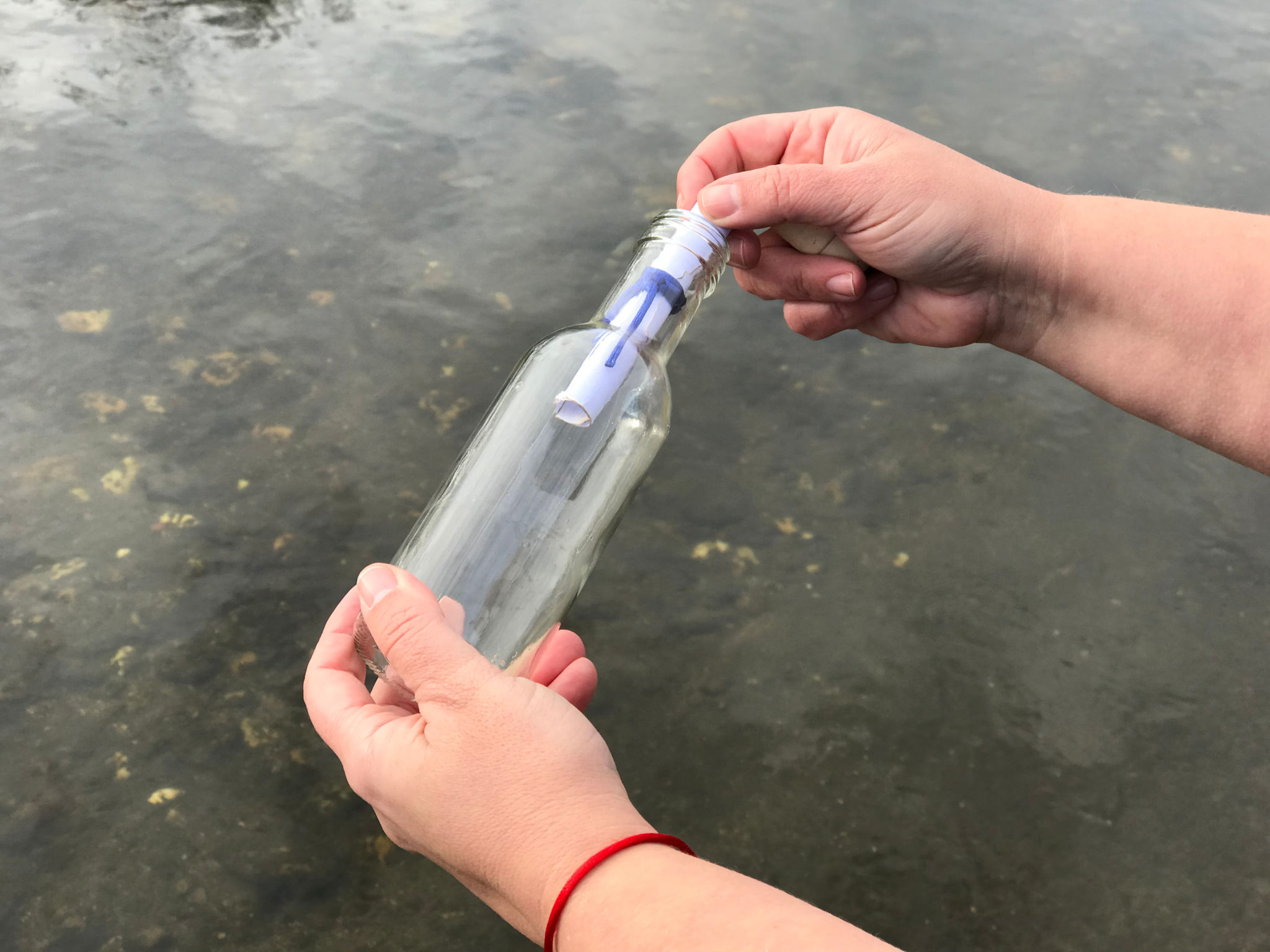 Cropped Hand Removing Message From Glass Bottle Cropped Hand Removing Message From Glass Bottle