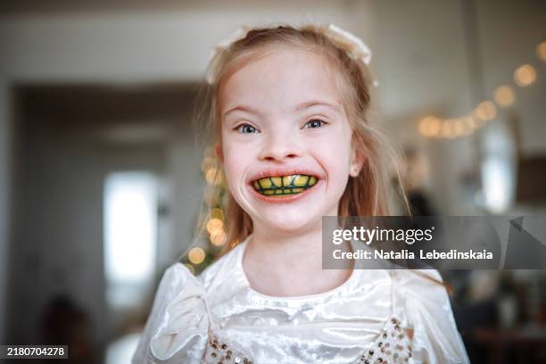 child girl smiling at home with yellow dental plate, focusing on bite correction and teeth alignment. - denture plates stock pictures, royalty-free photos & images