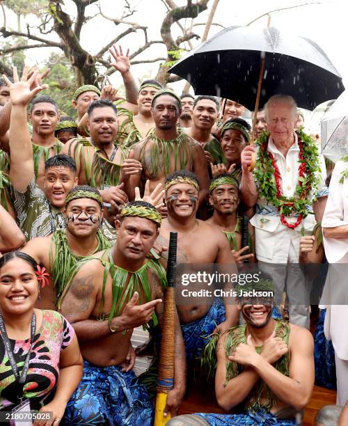 King Charles III and Queen Camilla pose with a local traditional cricket team members during his Samoa Cultural Village visit on October 24, 2024 in...