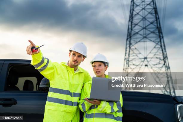 engineers collaborating at power station with laptop and radio - mirar alrededor fotografías e imágenes de stock