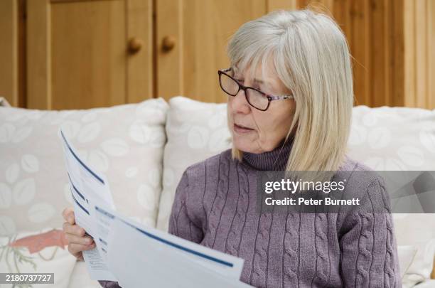 worried senior woman just received a bill - looking over stock pictures, royalty-free photos & images
