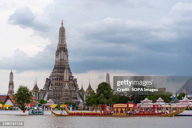 Rowers paddle ornate barges down the Chao Phraya River next to Wat Arun temple during the Royal Barge Procession in Bangkok. The Royal Barge...