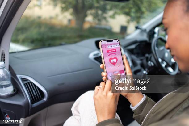checking her period app on the go - menstruation stock pictures, royalty-free photos & images