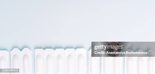 line of suppositories on blue background - suppository stock pictures, royalty-free photos & images