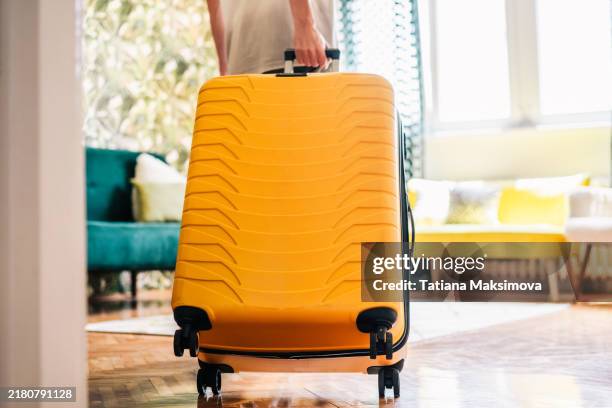 a young man with a yellow suitcase walks into a short-term rental apartment - hostel europe stock pictures, royalty-free photos & images