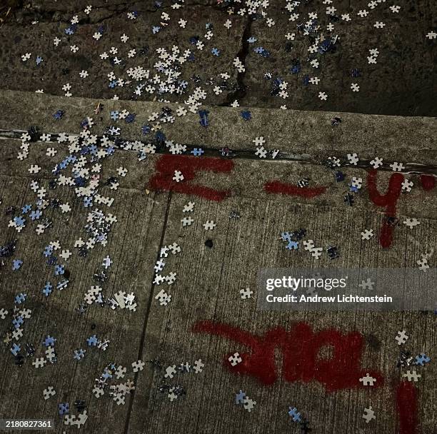 Scattered pieces of a jigsaw puzzle litter a sidewalk, November 26, 2023 in New York City, New York.