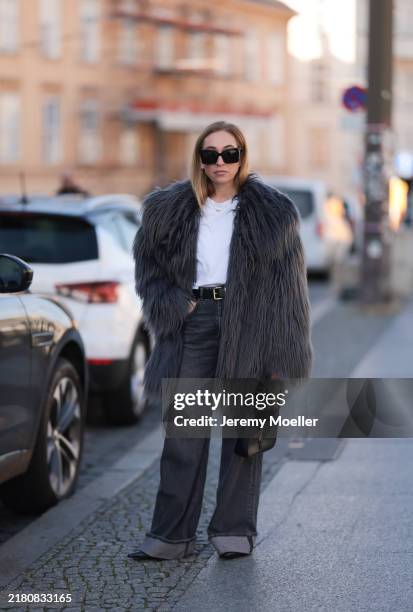 Sonia Lyson is seen wearing large black cat-eye sunglasses featuring extra-wide temples with gold logo-embellishment from Yves Saint Laurent, round...