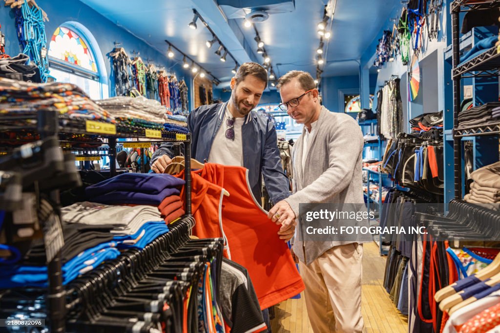 Gay men couple browsing the clothing store