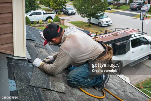 roofer works new roof tile cutting - telhado imagens e fotografias de stock