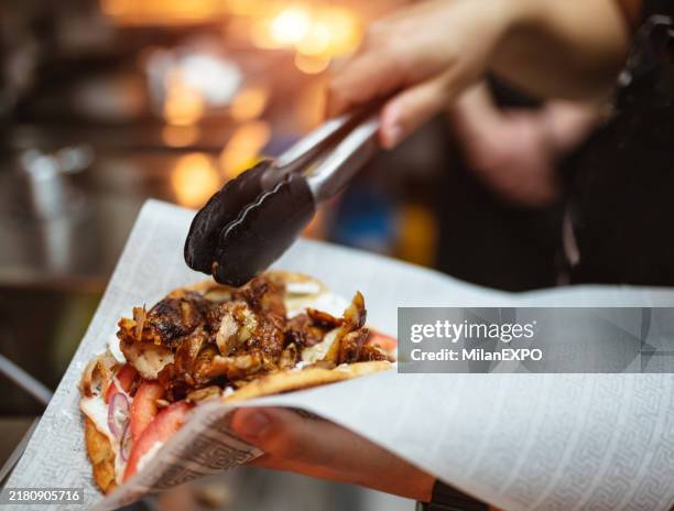 servicekraft bei der zubereitung von gyros-pita - kebab stock-fotos und bilder