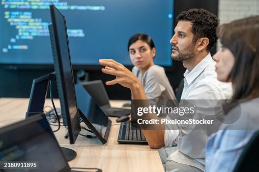Software developers checking programming code on computer screen. Software developers checking programming code on computer screen.