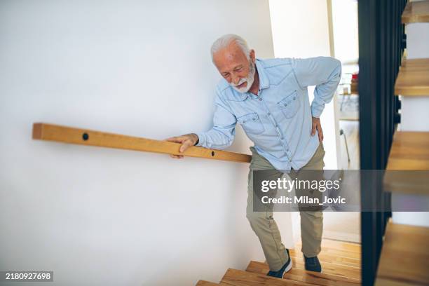senior man climbs the stairs with difficulty - gout leg stock pictures, royalty-free photos & images
