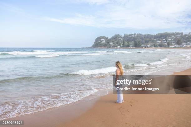back view of a teenage girl standing on a beach - avoca stock pictures, royalty-free photos & images