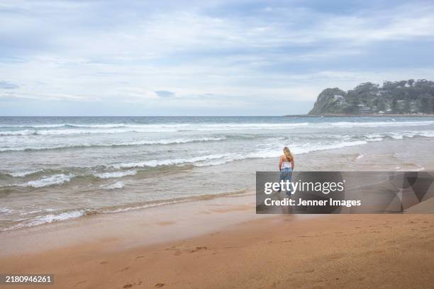 back view of a teenage girl standing on a beach - avoca stock pictures, royalty-free photos & images