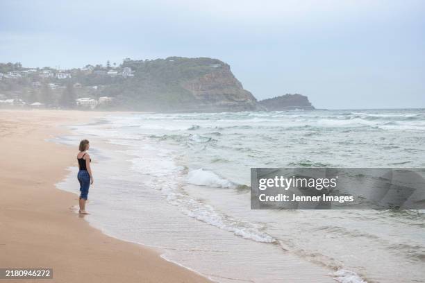 back view of a teenage girl standing on a beach - avoca stock pictures, royalty-free photos & images