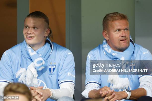 Manchester City's Norwegian forward Erling Haaland sits next to his father Alf-Inge Haaland in the stands during the Allsvenskan football match...