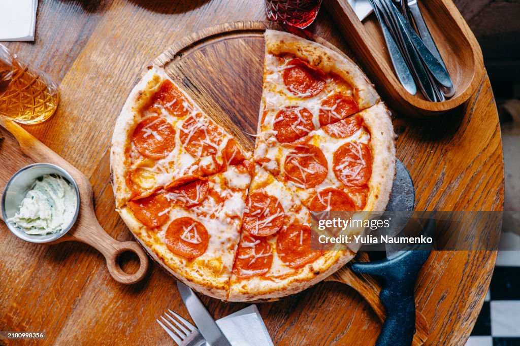 Pepperoni pizza on a table in a pizzeria.