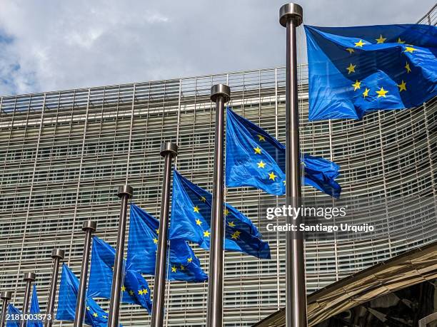 european union flags waiving in front of berlaymont building of the european commission - bandeira da união europeia imagens e fotografias de stock