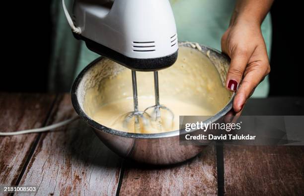 whips baking ingredients together - fouet photos et images de collection