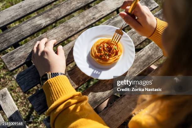 woman eating spaghetti by the river - autumn lake chair stock pictures, royalty-free photos & images