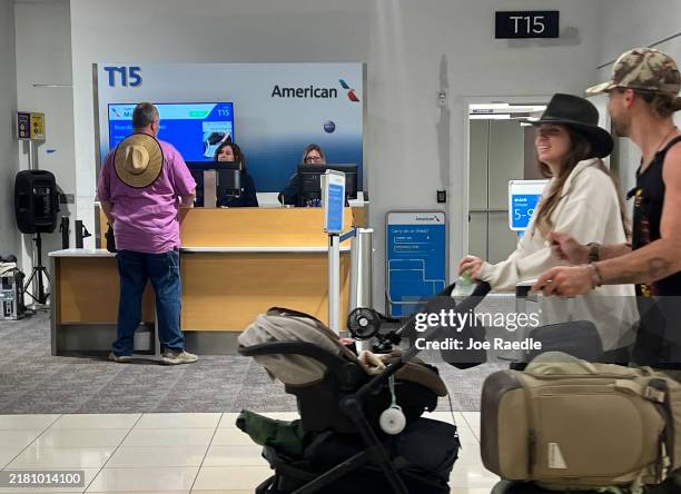 Passenger speaks with American airlines personnel before boarding an American Airlines flight in concourse T at the Hartsfield-Jackson Atlanta...