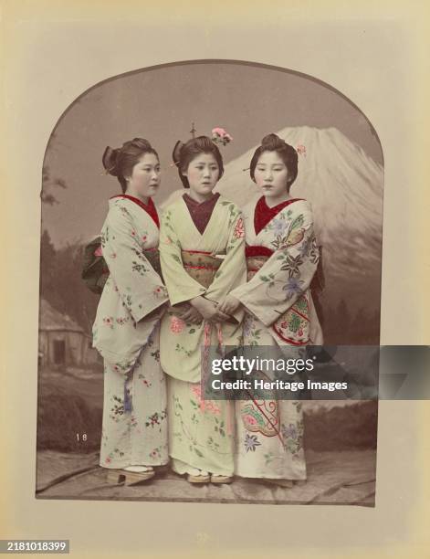 Three Girls, 1870s-1890s. Three girls in floral kimonos standing in front of a studio backdrop of Mt. Fuji. Creator: Kusakabe Kimbei.