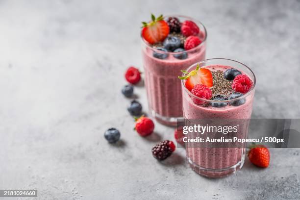 tasty healthy dieting red berry smoothie with chia seeds in glasses on grey background - smoothie stockfoto's en -beelden