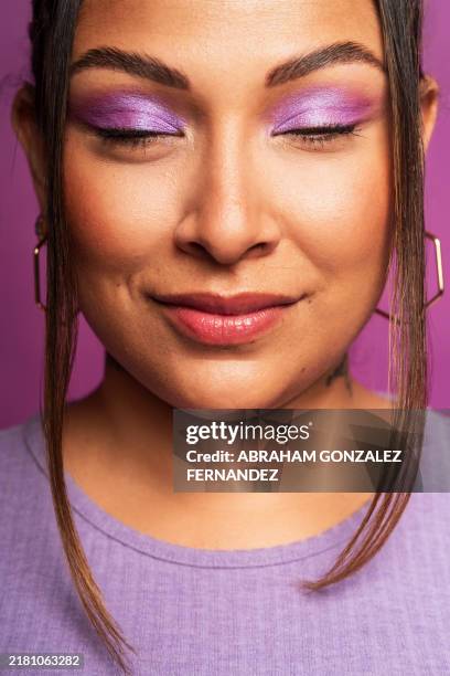 young latin woman with purple makeup closing her eyes and smiling - eye make up stock pictures, royalty-free photos & images
