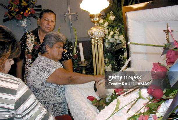 The body of the Mexican national Javier Suárez is guarded by family and friends 16 August 2002 in Piedras Negras, Mexico, two days after being...