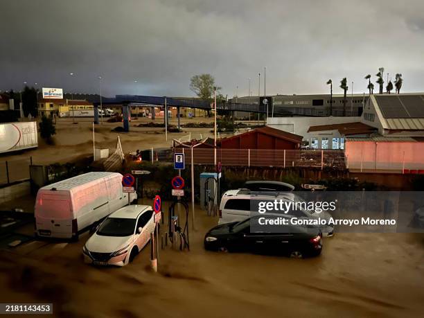 Cars are partly submerged in flood waters on October 29, 2024 on the western outskirts of Valencia, Spain. Spain's meteorological agency had issued...