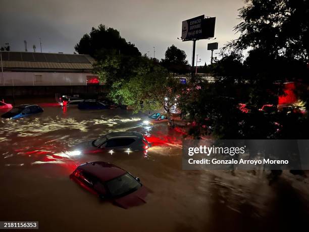 Cars are partly submerged in flood waters on October 29, 2024 on the western outskirts of Valencia, Spain. Spain's meteorological agency had issued...
