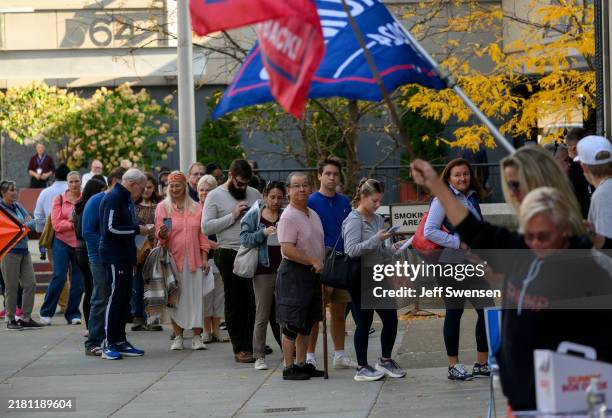 Voters line up to apply for their mail-in or absentee ballots outside the Allegheny County Office Building on October 29, 2024 in Pittsburgh,...