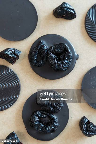overhead view of assortment of freshly made chocolates - dried plum stock pictures, royalty-free photos & images