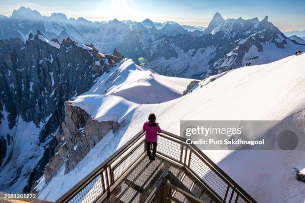 a woman looking at the view of the french alps from aiguille du midi in chamonix, france - french alps summer stock pictures, royalty-free photos & images