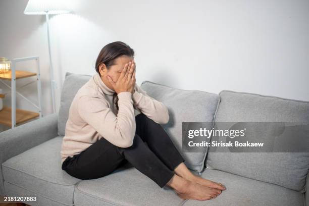 a sad and unhappy asian woman alone. her face shows thoughts of problems, hardships, feelings of failure and exhaustion. suffering from loneliness, sadness, a bad relationship or a breakup. - rejection stock pictures, royalty-free photos & images