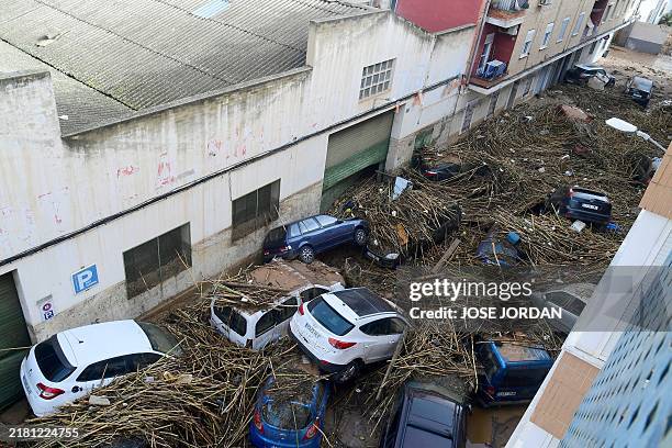 Picture taken in Picanya, near Valencia, eastern Spain, on October 30, 2024 shows cars piled in a stree after floods. Floods triggered by torrential...