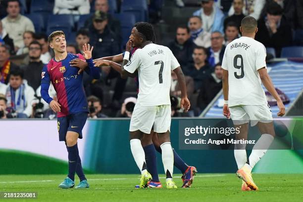 Gavi of FC Barcelona and Vinicius Junior of Real Madrid clash during the LaLiga match between Real Madrid CF and FC Barcelona at Estadio Santiago...