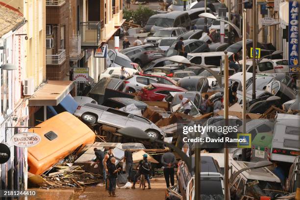 Cars are piled in the street with other debris after flash floods hit the region on October 30, 2024 in the Sedaví area of Valencia, Spain. Spanish...