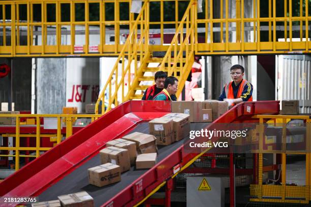 Employees sort express parcels at automated sorting lines in a distribution center of J&T Express ahead of China's Double 11 Shopping Festival on...