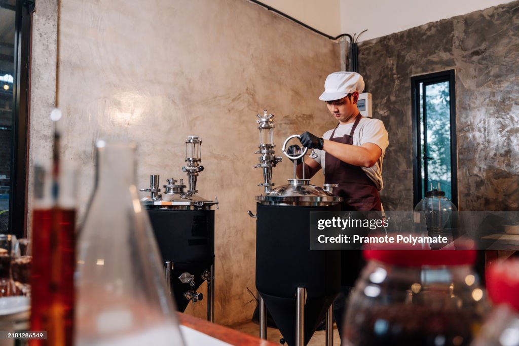 Asian brewer preparing equipment for brewing craft beer in a rural brewery