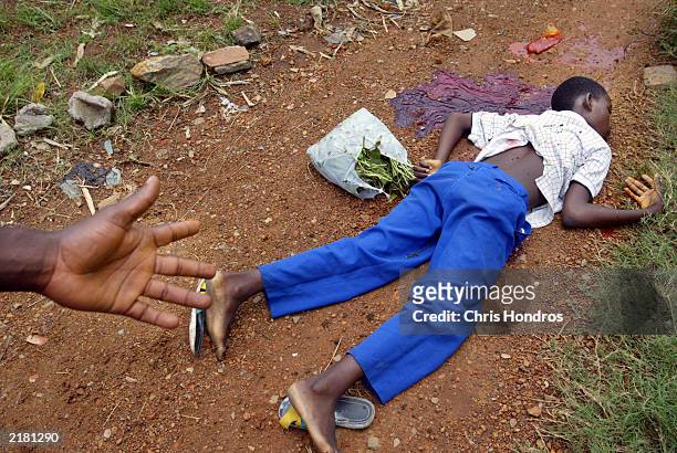 The body of school child Lasana Harding lies on a dirt path about two minutes after he was killed my a mortar shell July 21, 2003 in Monrovia,...
