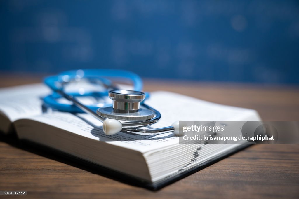 Medical textbook and stethoscope on desk,Education concept.