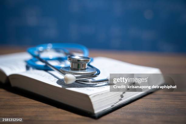medical textbook and stethoscope on desk,education concept. - medical school stock pictures, royalty-free photos & images
