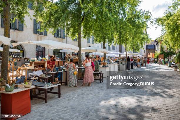mercado de alfarería y cerámica al aire libre bajo los árboles en cremieu, ciudad francesa con turistas - artesanos fotografías e imágenes de stock