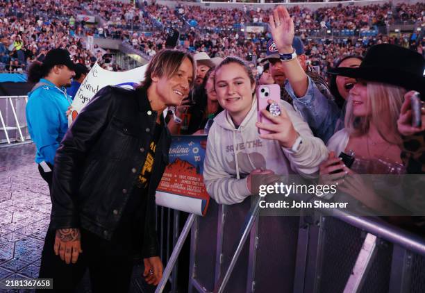 Keith Urban poses for a selfie with a fan at the Concert For Carolina Benefit Concert at Bank of America Stadium on October 26, 2024 in Charlotte,...
