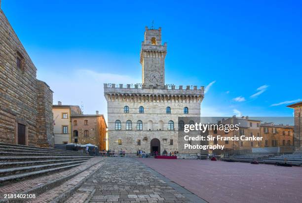 facade of medieval town hall ("palazzo comunale") of montepulciano on "piazza grande" with colorful houses in siena, tuscany, italy - montepulciano stock pictures, royalty-free photos & images