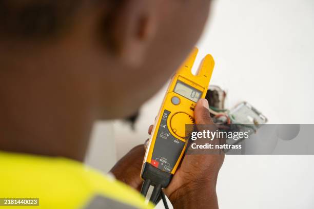 electrician testing the power with an electrical tester - multimeter stock pictures, royalty-free photos & images