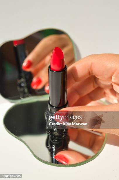 hand holding a red lipstick - woman holding hand mirror stock pictures, royalty-free photos & images